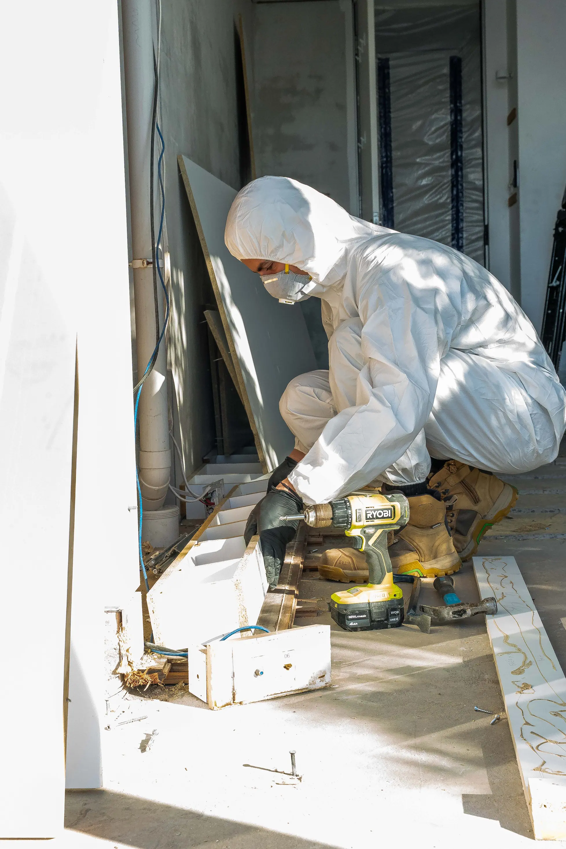 Technician unscrewing affected joinery from a stripped floor slab