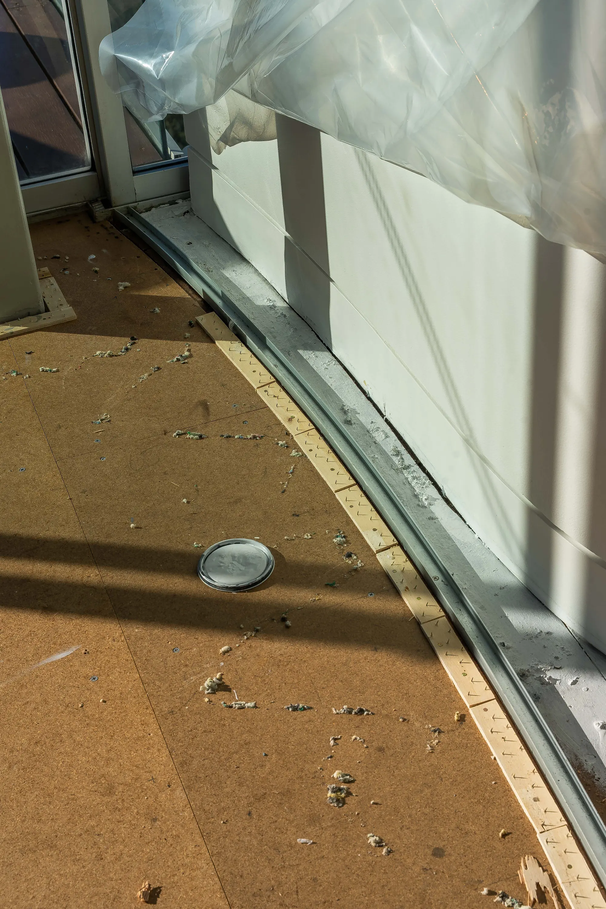 Technician sealing wrapped floor materials inside a plastic containment area