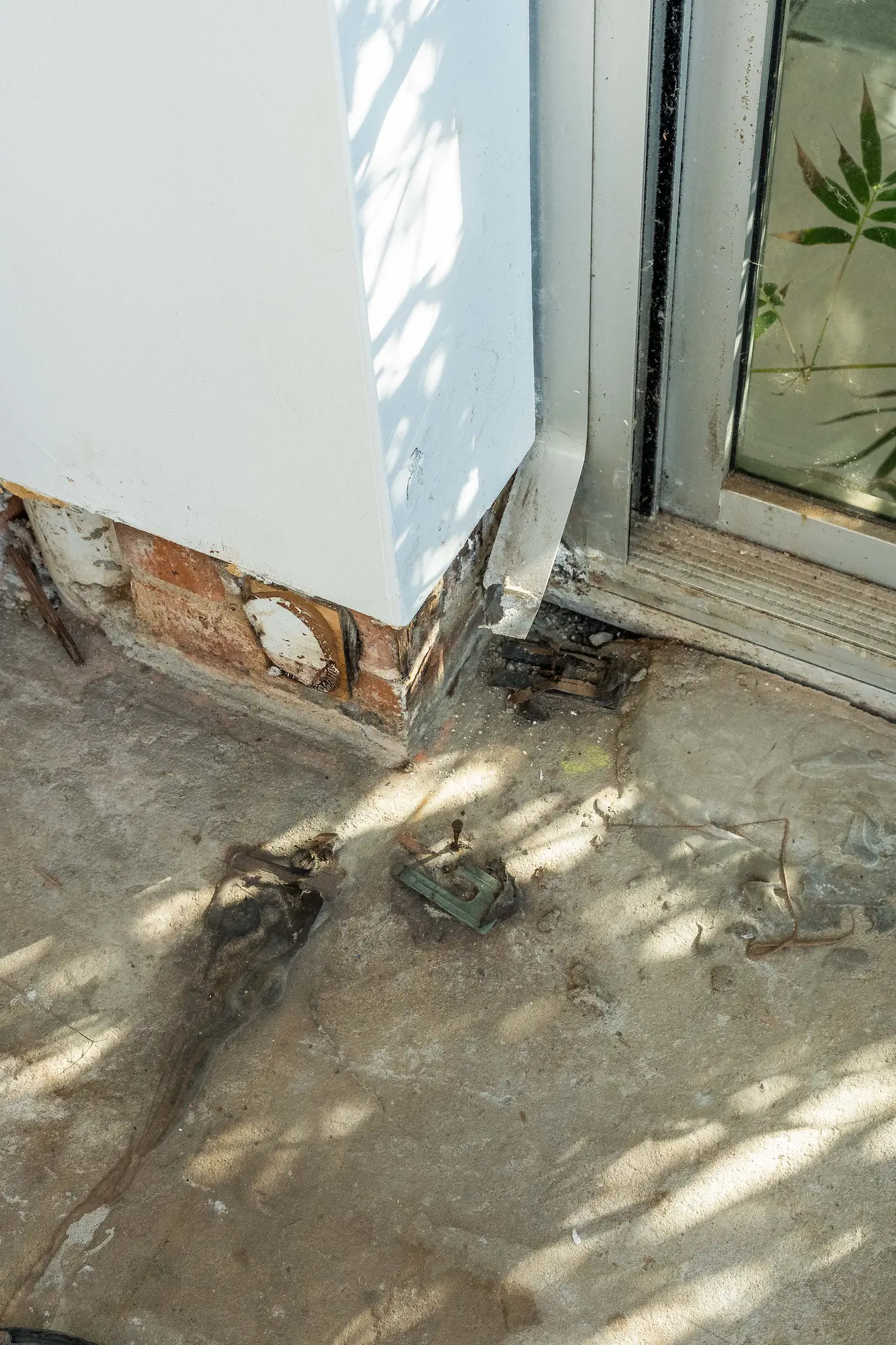 Tack strips being lifted from a concrete slab with bagged contents nearby